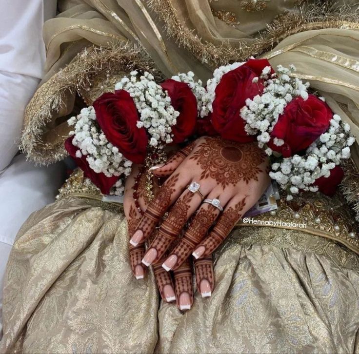 a woman's hands with henna and flowers on it