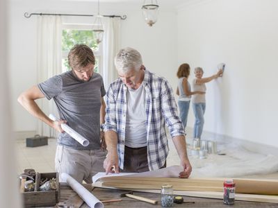 two men standing in a room with construction materials