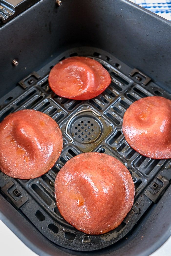 four donuts are being cooked in an air fryer