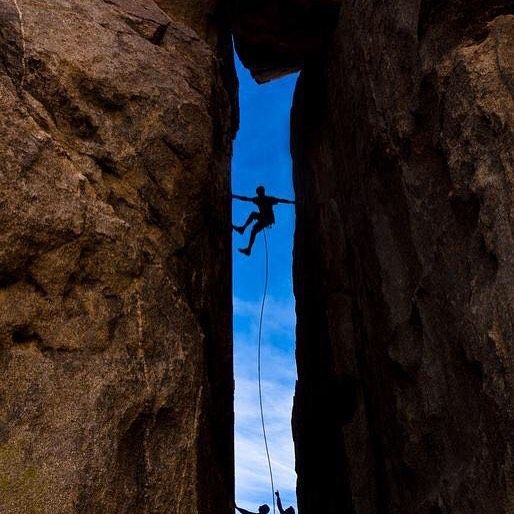 a man climbing up the side of a cliff