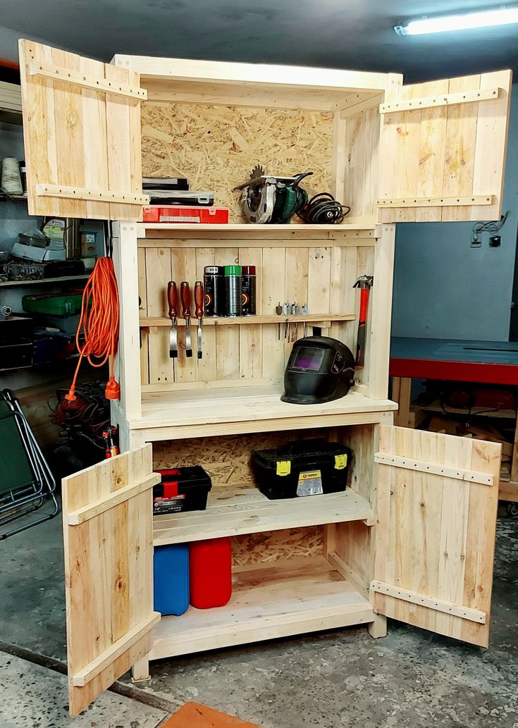 a wooden cabinet with tools and other items in it