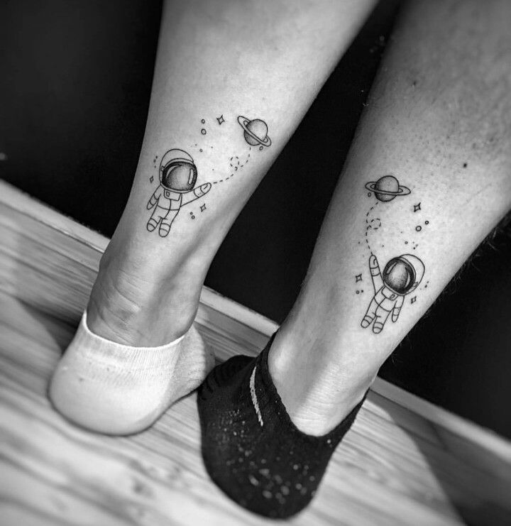 two people with tattoos on their legs and one has an astronaut's foot tattoo