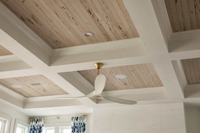 a ceiling fan is mounted to the ceiling in a room with white walls and wood paneling