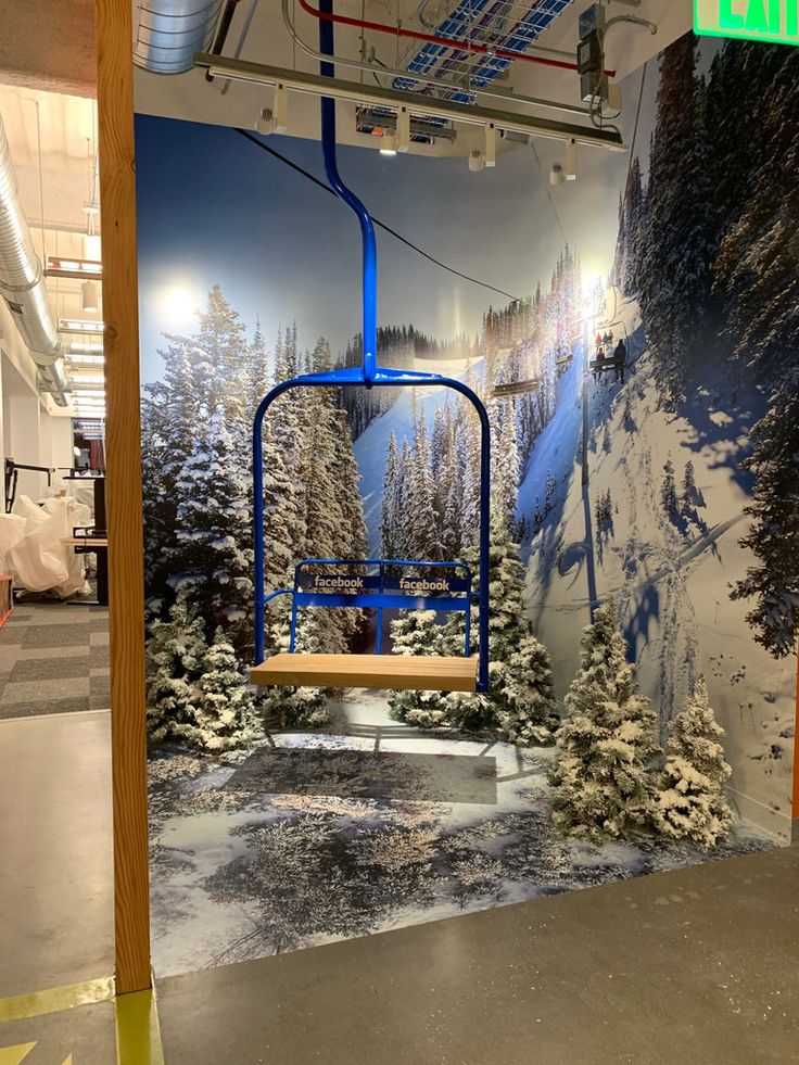 a ski lift in the middle of a snow covered area with trees and bushes on it