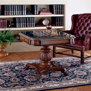 a living room with a table and chairs in front of a book shelf filled with books