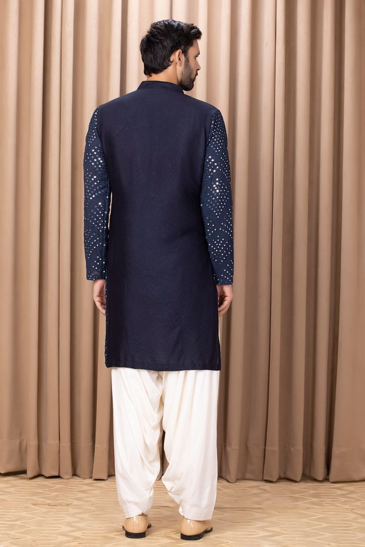 Midnight blue straight kurta with mirror embroidery on the front and sleeves. Comes with dhoti pant.
Component: 2
Pattern: Embroidered
Type Of Work: Mirror Work
Neckline: Mandarin Collar
Sleeve Type: Straight Long
Fabric: Pure Georgette, Lining: Cotton
Color: Blue
Occasion: Wedding - Aza Fashions Mirror Work Kurta, Mirror Embroidery, Kurta Set For Men, Dhoti Pants, Types Of Work, Blue Mirror, Straight Kurta, Mirror Work, Kurta Set