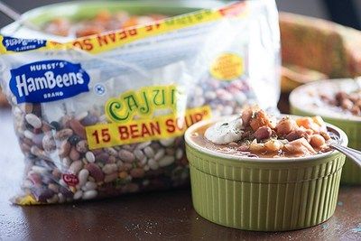 two bags of food sitting on top of a wooden table next to bowls and spoons