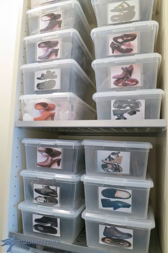 several plastic bins filled with shoes on top of a shelve in a closet