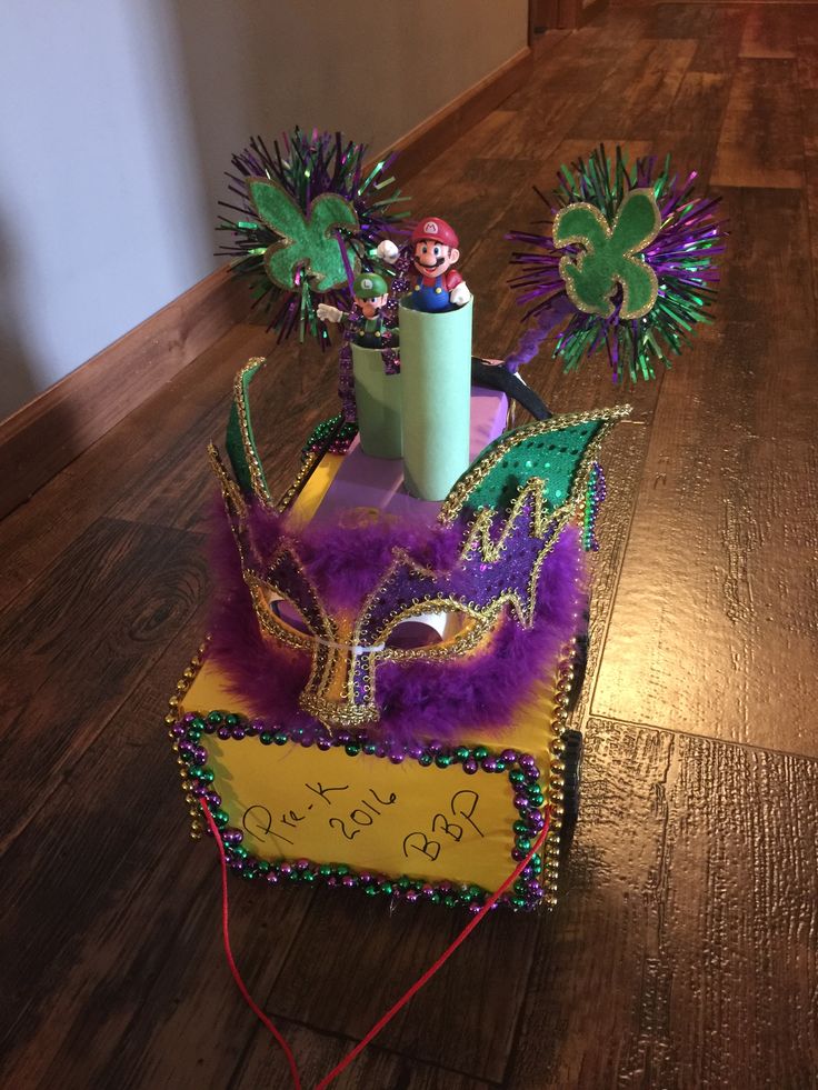 a mardi gras mask on top of a box with other decorations around it