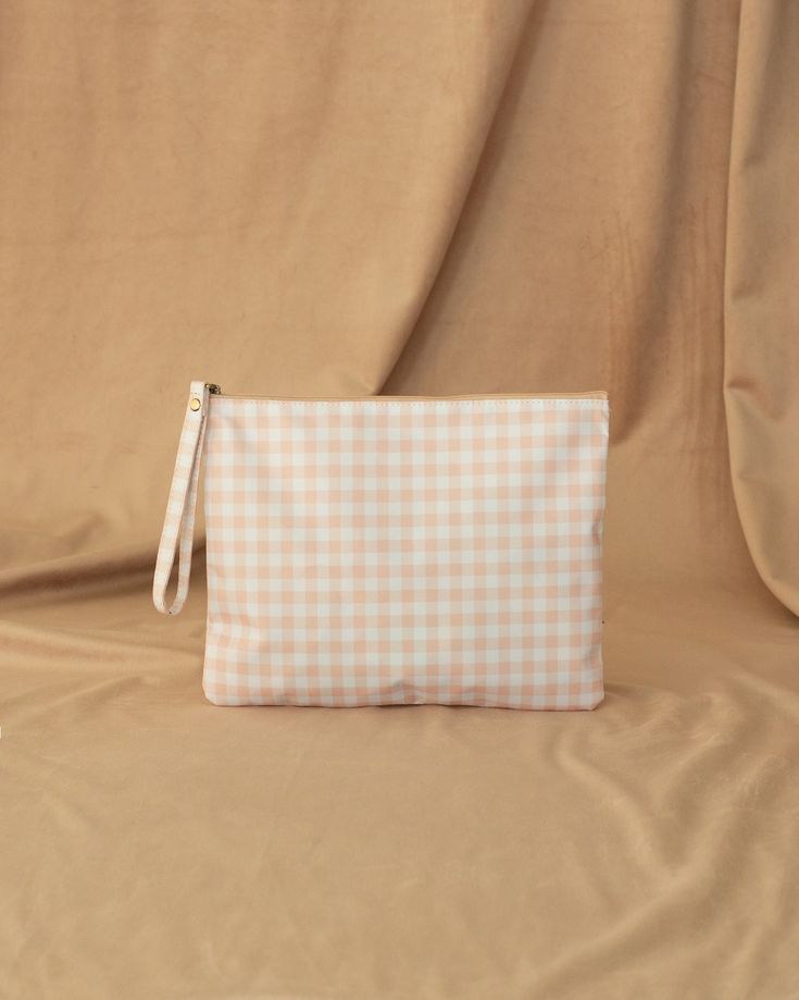 a white and blue checkered pouch sitting on top of a bed