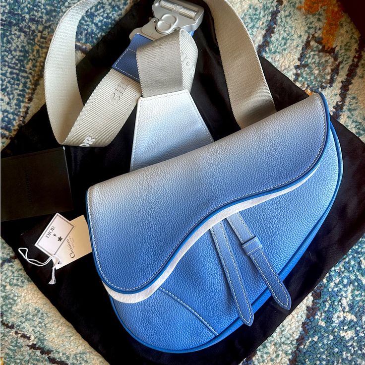 Experience The Fusion Of Art And Fashion With The Dior X Daniel Arsham Limited Edition Blue Ombr Saddle Bag. This Exclusive Piece Was Purchased In 2019 At The Iconic Dior On Rodeo Drive In Beverly Hills, Ensuring Its Authenticity. The Bag Showcases A Captivating Ombr Effect In Shades Of Blue, Adding To The Timeless Saddle Bag Silhouette. It Remains In Pristine, Unused Condition With Tags And Original Packaging Intact. Blue Luxury Leather Saddle Bag, Luxury Blue Leather Saddle Bag, Bag Silhouette, Daniel Arsham, Mens Monogram, Leather Messenger Bag Men, Crossbody Saddle Bag, Art And Fashion, Rodeo Drive