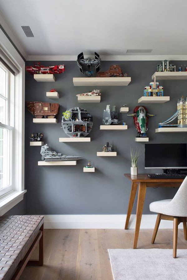 a room with some shelves on the wall and a desk in front of it,