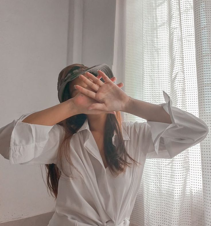 a woman is covering her eyes with her hands