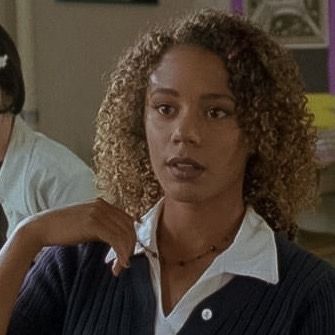 a woman with curly hair standing next to a man