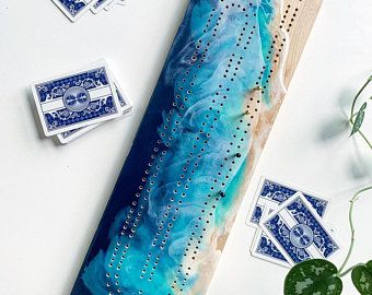 some blue and white tiles are laying on a table next to a potted plant