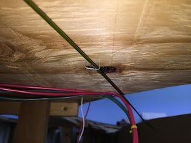 an electrical wire is attached to the underside of a wooden structure with wires running through it