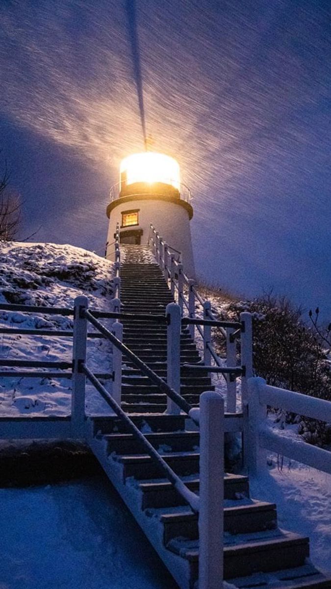 stairs lead up to a light house in the snow