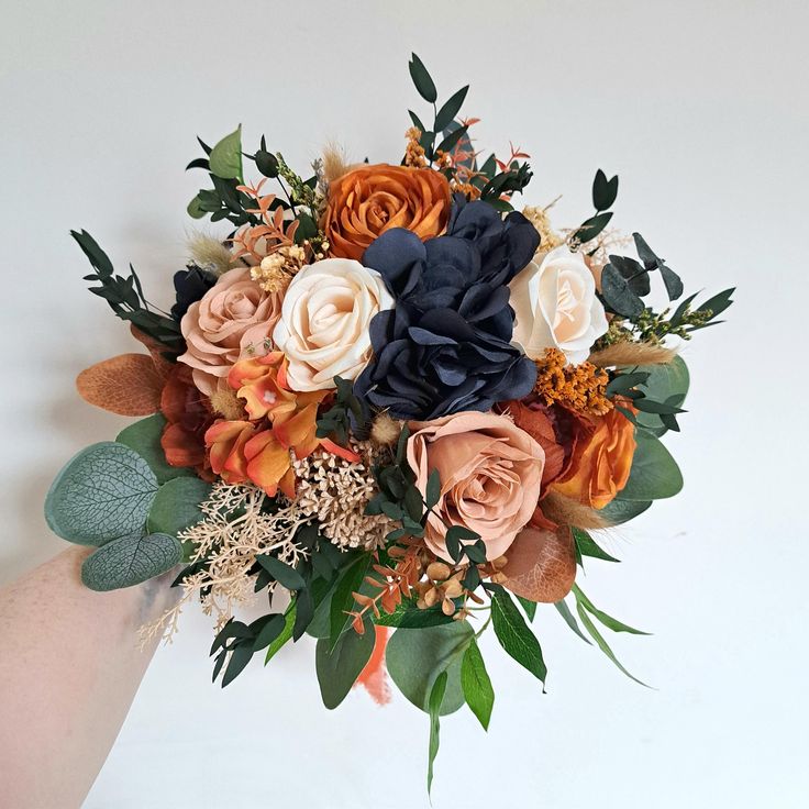 a bouquet of flowers is being held by someone's hand on a white background