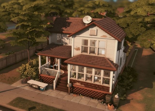 an aerial view of a two story house with a porch and covered front yard area