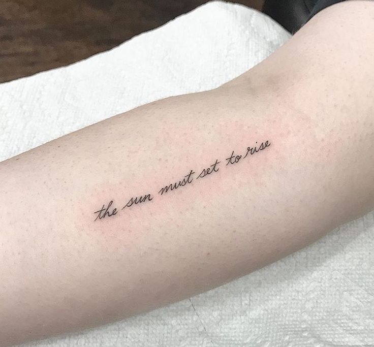 a person with a tattoo on their arm that says, the sun must not rise