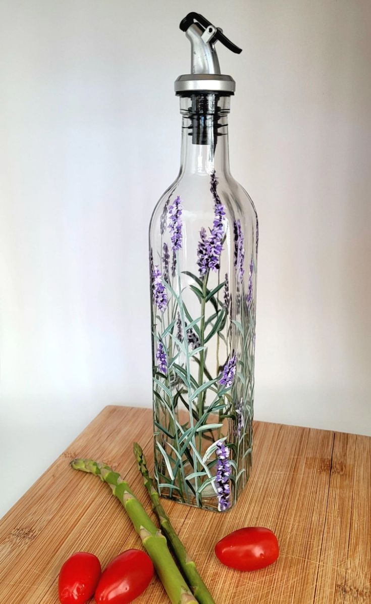 a glass bottle sitting on top of a wooden table next to tomatoes and asparagus