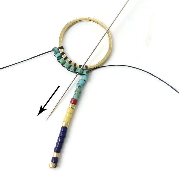 a pair of scissors and some beads on a white surface with an arrow in the middle