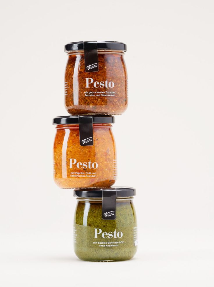 three jars of pesto are stacked on top of each other