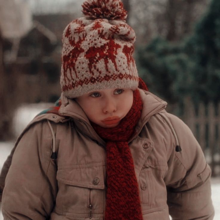 a young boy wearing a red and white knitted hat, scarf and neck tie