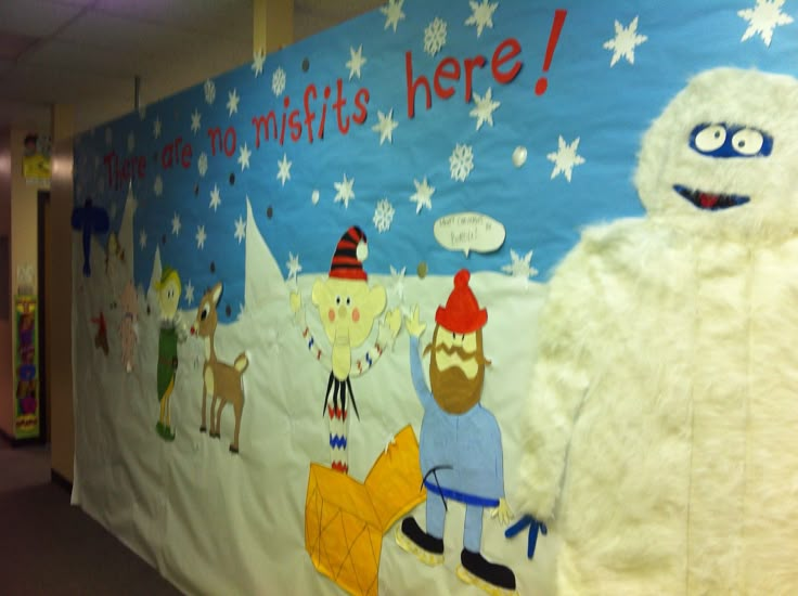 a bulletin board with cartoon characters on it in an office cubicle decorated for christmas