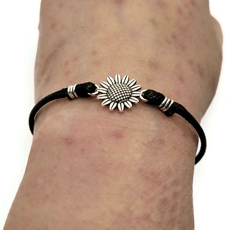 This 0.8-inch sunflower charm comes on a vegan friendly, faux leather cord with lobster clasp. Bracelet includes special card and gift box. Choose your size. Sizes come with a 2 inch extender, great for gift giving when you don't know the recipient's size! Trendy Adjustable Jewelry With Flower Charm, Adjustable Trendy Jewelry With Flower Charm, Flower-shaped Jewelry With Adjustable Cord For Gifts, Flower Shaped Jewelry With Adjustable Cord As A Gift, Casual Metal Jewelry With Adjustable Cord, Adjustable Silver Leather Bracelet With Lobster Clasp, Everyday Nickel-free Jewelry With Waxed Cord, Nickel-free Waxed Cord Jewelry For Everyday, Adjustable Black Jewelry With Flower Charm