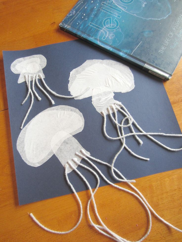 the paper is cut out to look like jellyfishs and are sitting on a table