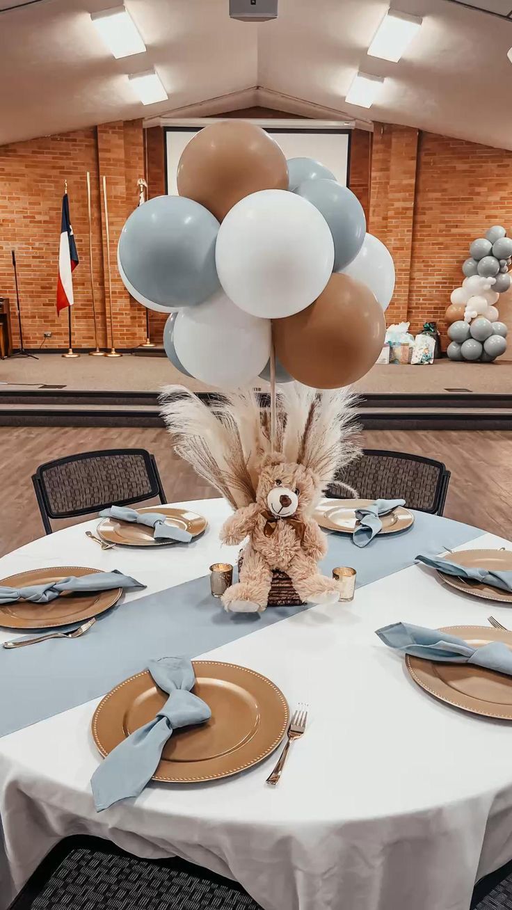 a table set with plates, silverware and balloons