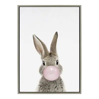 a rabbit with a bubble gum in its mouth is framed on the wall above a table