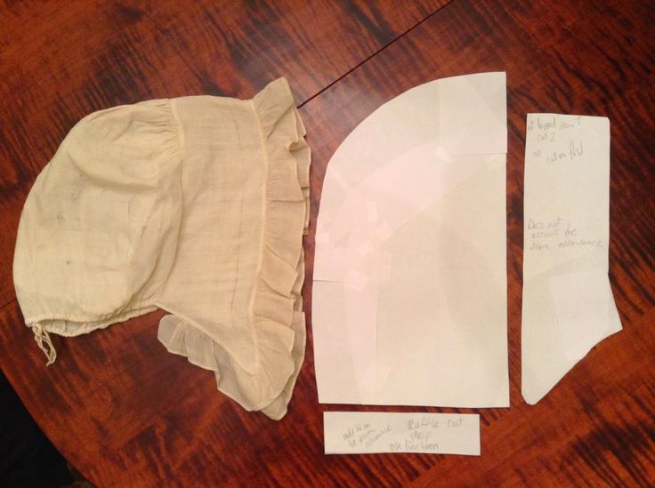 three pieces of cloth are laid out on a wooden table with paper attached to them