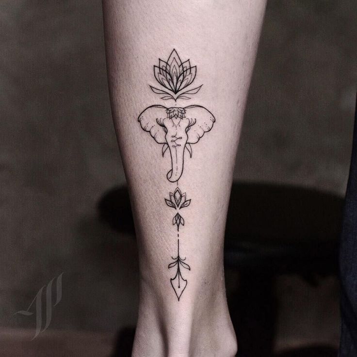 an elephant and flower tattoo on the foot