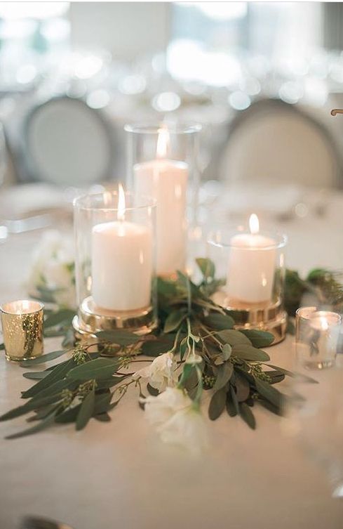 the table is set with candles and greenery