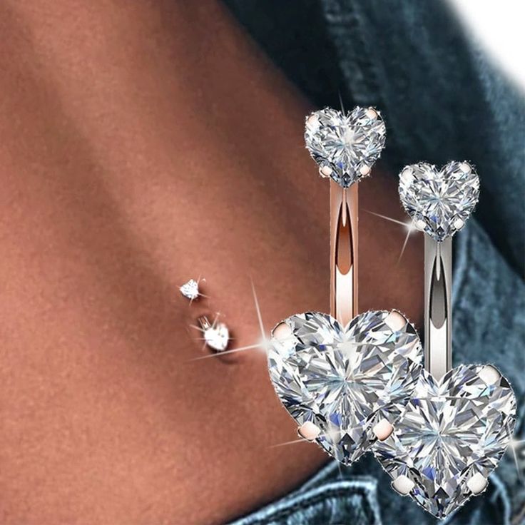 a pair of heart - shaped diamond earrings on the back of a woman's stomach