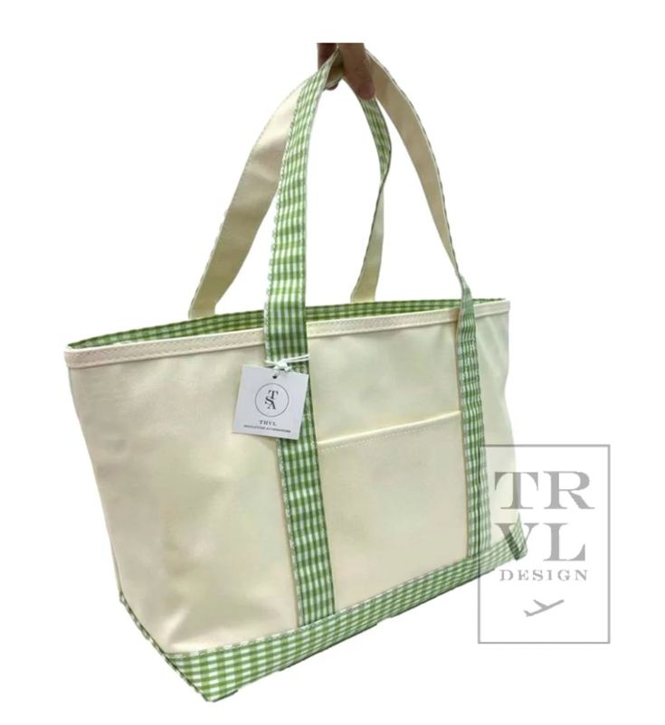 The New Midi Tote in coated canvas - is perfect for day-to-day, beach, groceries, and getaways. This roomy interior can carry a 17" laptop, change of clothing and our other TRVL accessories. Designed with Signature coating that is wipeable and machine washable Includes front exterior pocket and inside key clip strap. Size: 13"| (base) x 10.5"h x 6"d - top width 19" Handle Drop: 8.25" Cotton canvas with Signature * Coating Set-in collar with Chunky White Zipper closure Key Ring Keeper Water and stain resistant & wipeable inside and out Care: wipe with a clean damp cloth Green Canvas Bag With Canvas Lining For Travel, Green Rectangular Canvas Bag For The Weekend, Green Rectangular Canvas Bag For Weekend, Green Canvas Tote Travel Bag, Green Canvas Rectangular Weekender Bag, Green Rectangular Canvas Weekender Bag, Cotton Beach Bag With Pockets For Travel, Cotton Beach Bag With Canvas Lining For Travel, Casual Beach Bag With Canvas Lining For Travel