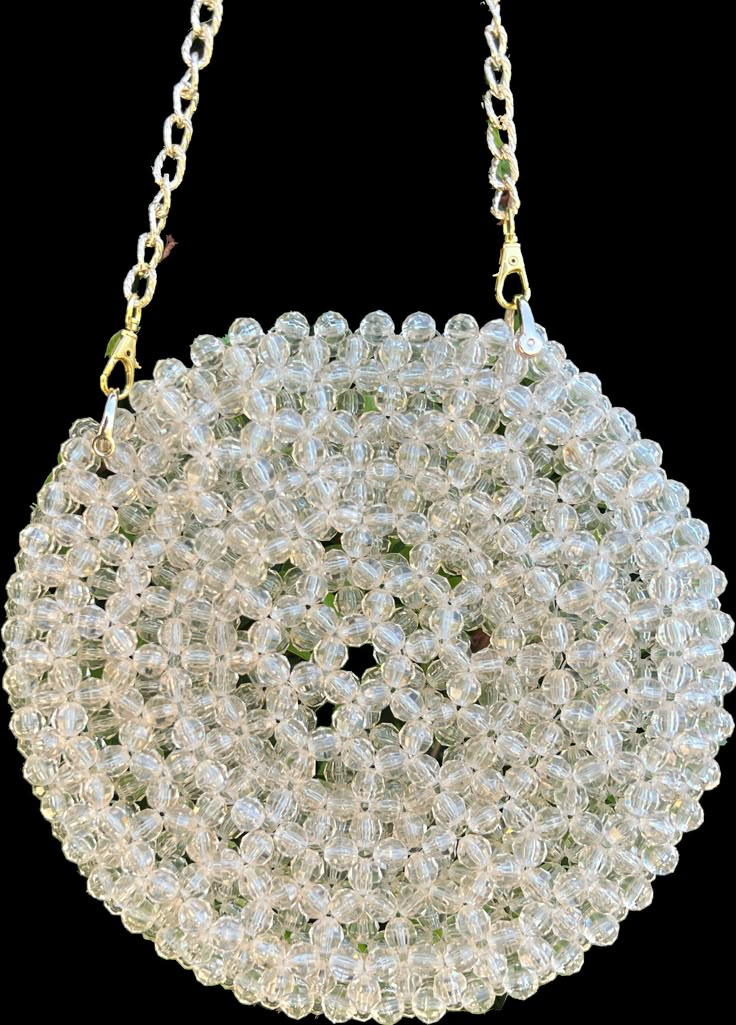 a white beaded purse hanging from a chain