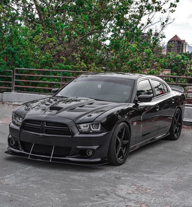 a black dodge charger parked in a parking lot