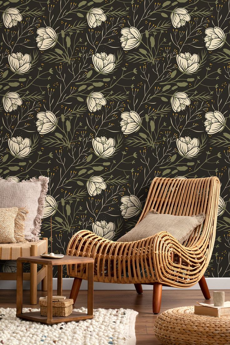 a wicker chair sitting in front of a wallpapered with flowers and leaves