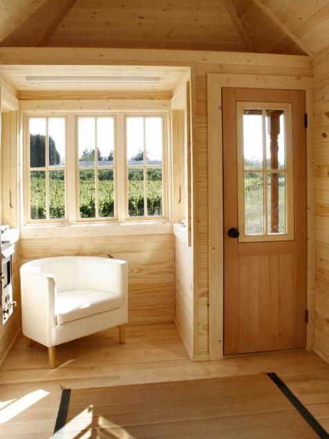 the interior of a small cabin with wood paneled walls and flooring is shown