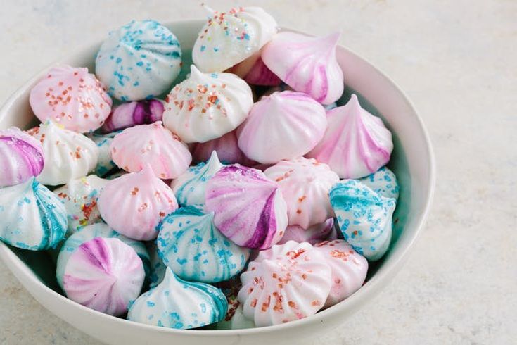 a white bowl filled with lots of colorful candy