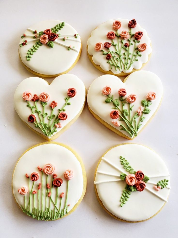 six decorated cookies with flowers on them are arranged in the shape of heart shaped cookies