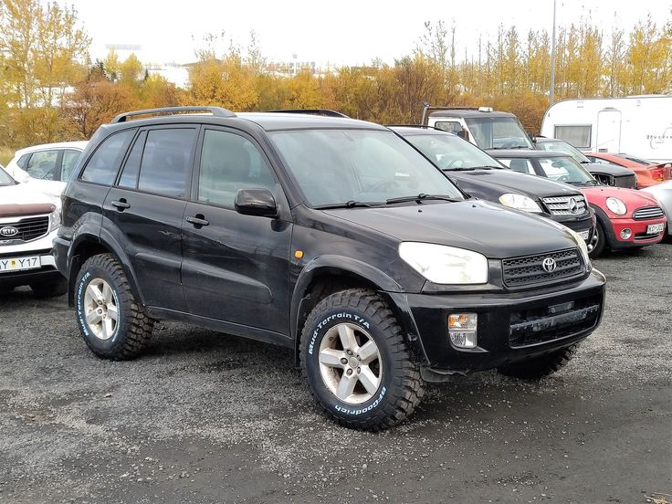 a black suv parked in a parking lot next to other cars