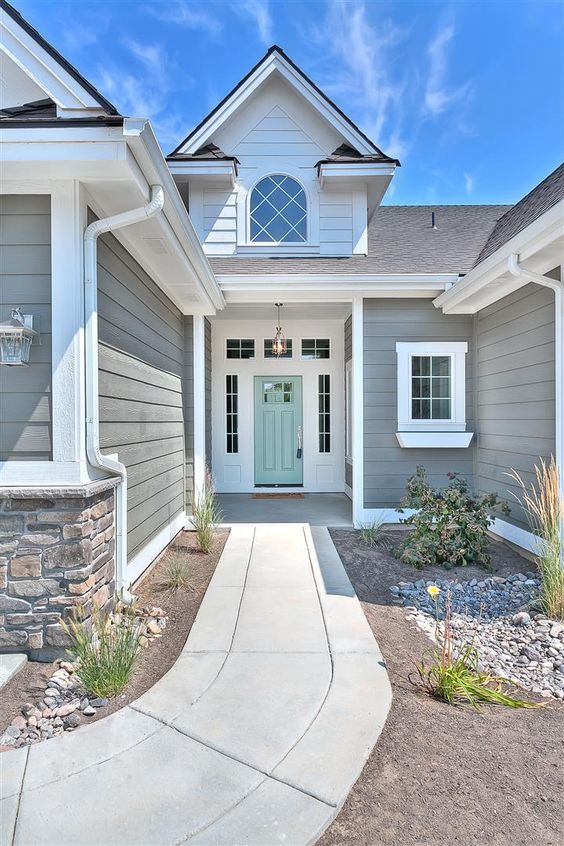 a house with gray siding and white trim on the front door is shown in this photo