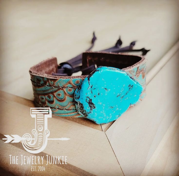 Show off your boho chic style with this women's leather cuff bracelet! This piece of genuine leather cuff jewelry features two leather strips sewn back-to-back, making it reversible This women's cuff bracelet is handcrafted with genuine leather, adding a Southern touch to your boho chic style. Wear this wide leather cuff bracelet alone or add Navajo turquoise bracelets, amazonite bracelets, and more from our bracelet bar to create your own look. Accented with a turquoise stone. Adjusts with leather ties and a wood bead that can be moved to accommodate a variety of wrist sizes. This women's cuff bracelet is 1" in width by 9" in length, and it adjusts with to the smallest size approx 5" up to approx. Jean Jewelry, Bracelet Bar, Turquoise Bracelets, Womens Cuff Bracelets, Amazonite Bracelet, Leather Cuff Bracelet, Cuff Jewelry, Boho Chic Style, Navajo Turquoise