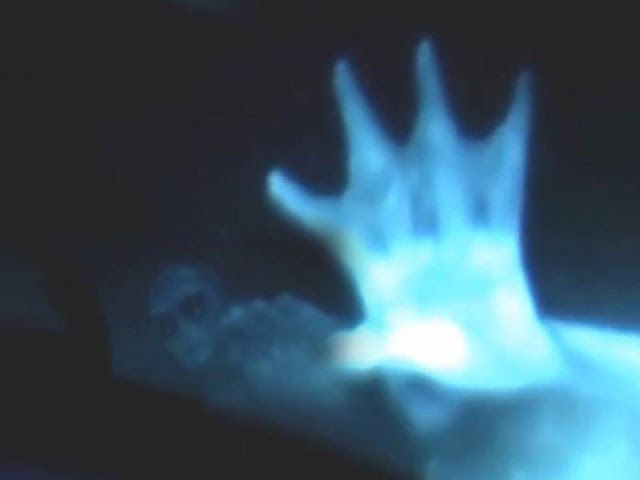 a blurry image of a hand reaching up into the air