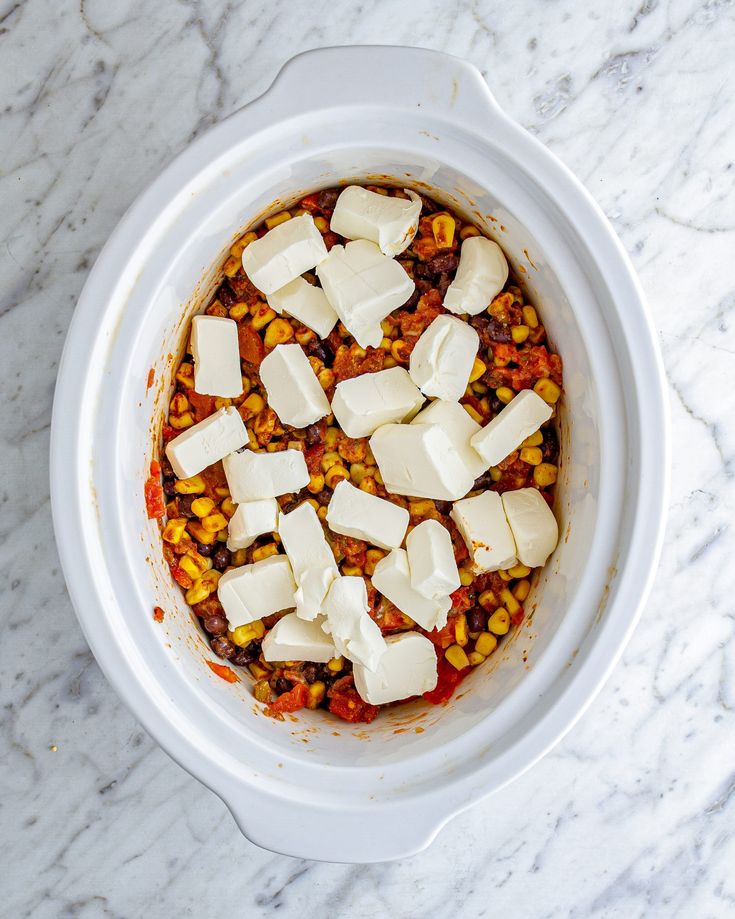 a white bowl filled with food on top of a marble counter