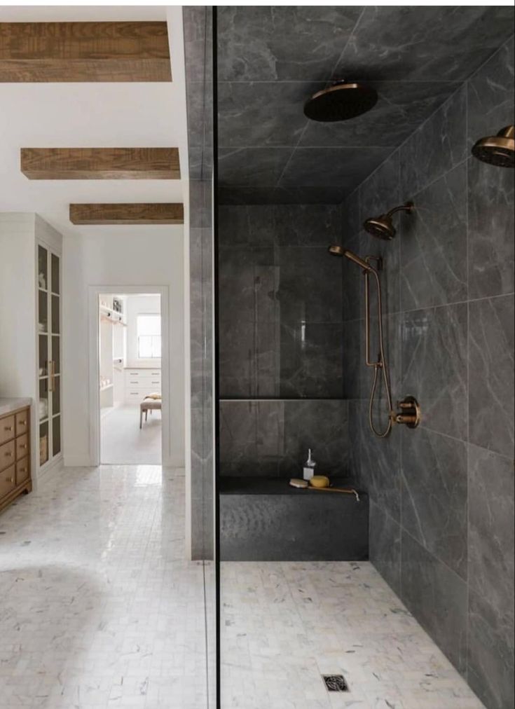 a bathroom with marble walls and flooring next to a bathtub in the corner